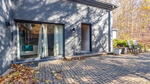 A modern building with large glass doors and windows, a paved driveway, and outdoor seating. - Luxury Hot tub Suite w/ In-Room Hot Tub & King Bed 1BR, 1BA (Nashville)