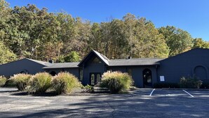 A building with a dark facade, arched windows, and a parking lot in front. - Luxury Hot tub Suite w/ In-Room Hot Tub & King Bed 1BR, 1BA (Nashville)