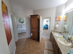 A bathroom with two sinks, a mirror, and a wooden cabinet.
