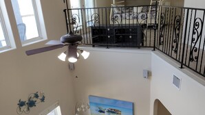 A multi-level living space with a sofa, armchairs, a small table, and a ceiling fan. - Island Waterfront 3/2 Private Pool & Hot Tub with Boat Dock (Corpus Christi)