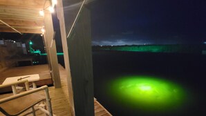 A wooden deck with a railing, a table, and a bench. - Island Waterfront 3/2 Private Pool & Hot Tub with Boat Dock (Corpus Christi)