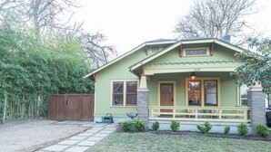 A two-story house with a front porch, a mailbox, and a small garden. - Walkable SoCo Bungalow (Austin)