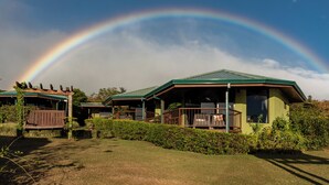 A house with a green roof and a porch, surrounded by greenery. - Hotel Trópico Monteverde (Monteverde)