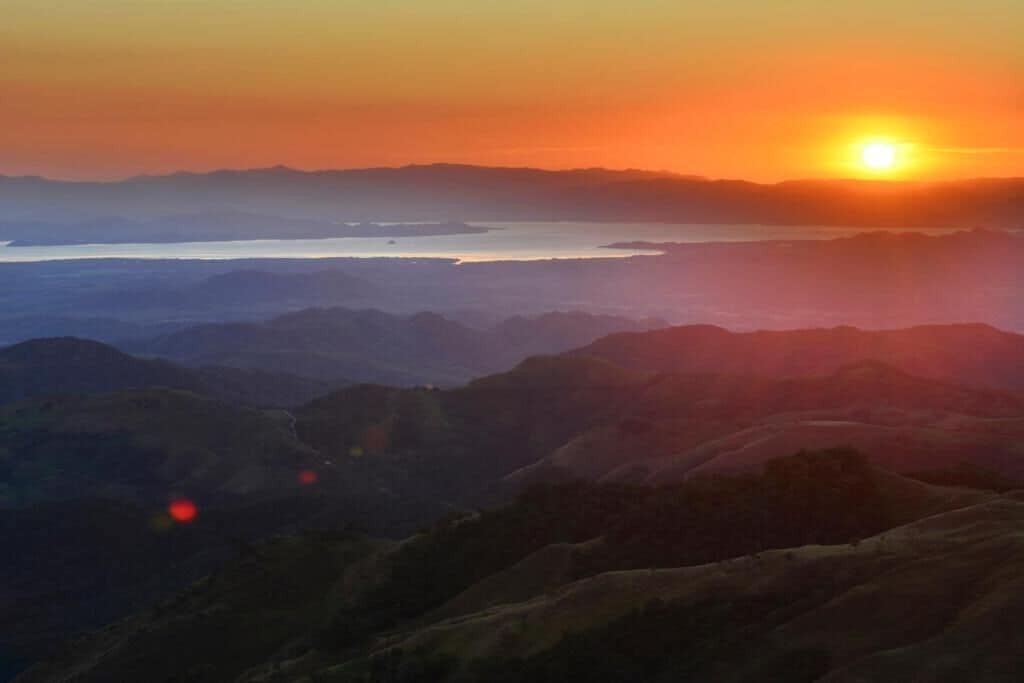 A panoramic view of a mountainous landscape during sunset.