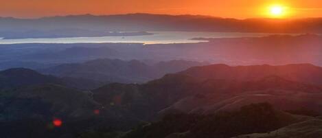 A panoramic view of a mountainous landscape during sunset.