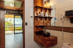 A bathroom with wooden shelves, a sink, and a hairdryer. - Hotel Trópico Monteverde (Monteverde)