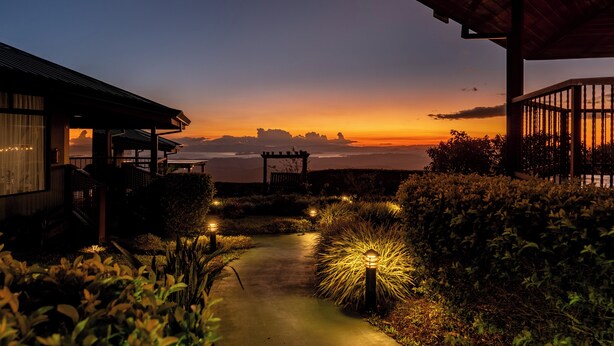 A pathway leading to a building with a view of the sunset. - Hotel Trópico Monteverde (Monteverde)