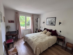 A bedroom with a bed, a desk, a chair, a bookshelf, and a window with curtains. - Two houses in a beautiful garden in Carnac, ideal for 2-3 families with children (Carnac)