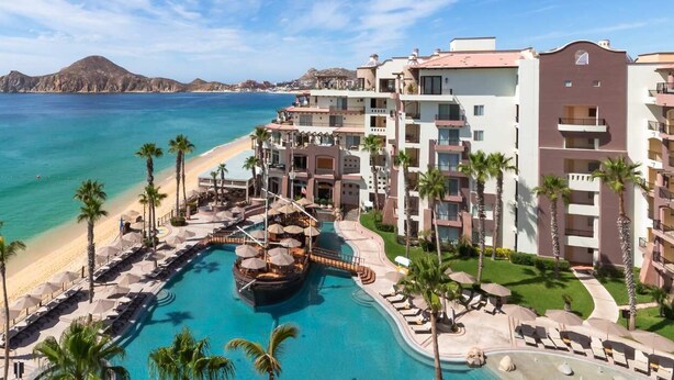 Un complexe hôtelier doté d’une piscine, d’une plage et offrant une vue sur l’océan.