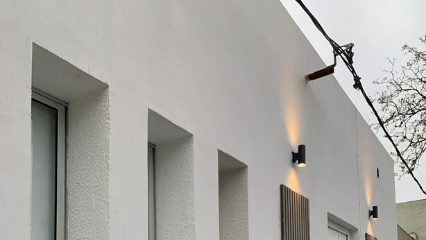 Un edificio moderno con ventanas amplias y fachada blanca y minimalista.