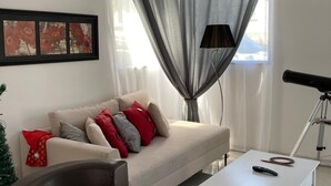 Un salón moderno con un sofá, una mesa de centro, un sillón de cuero y un telescopio.