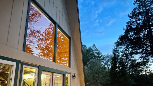 Una casa moderna con terraza, mobiliario exterior y una chimenea.