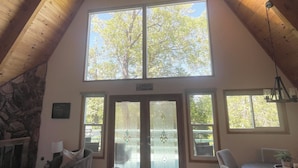 Un acogedor dormitorio en el ático con techo alto, ventanas amplias, chimenea y zona de comedor.