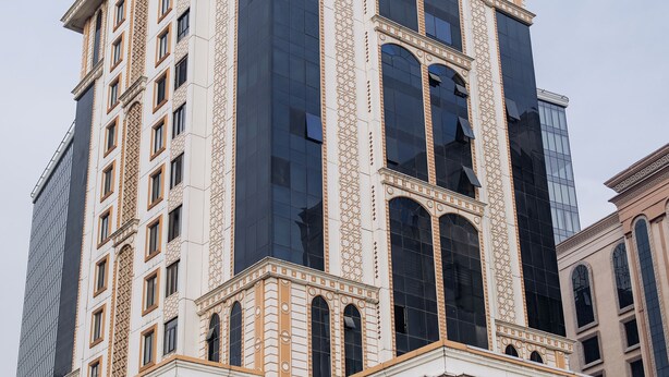 A tall building with classical architectural elements, including columns and decorative moldings. - Urban Sanctuary in the Heart of Dushanbe w/Stunning Views Steps from Rudaki Park (Dushanbe)