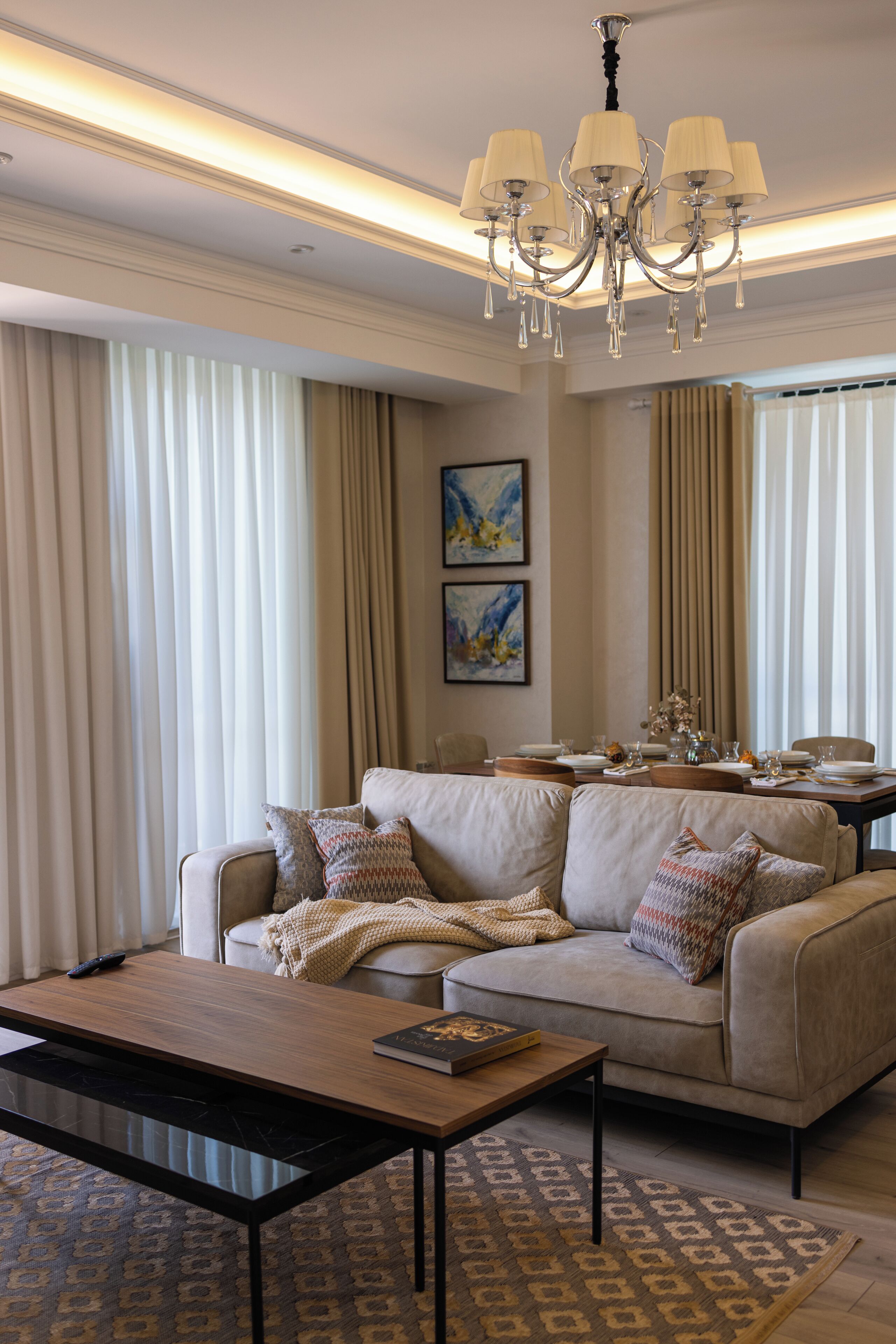 A living room with a sofa, coffee table, and a chandelier.