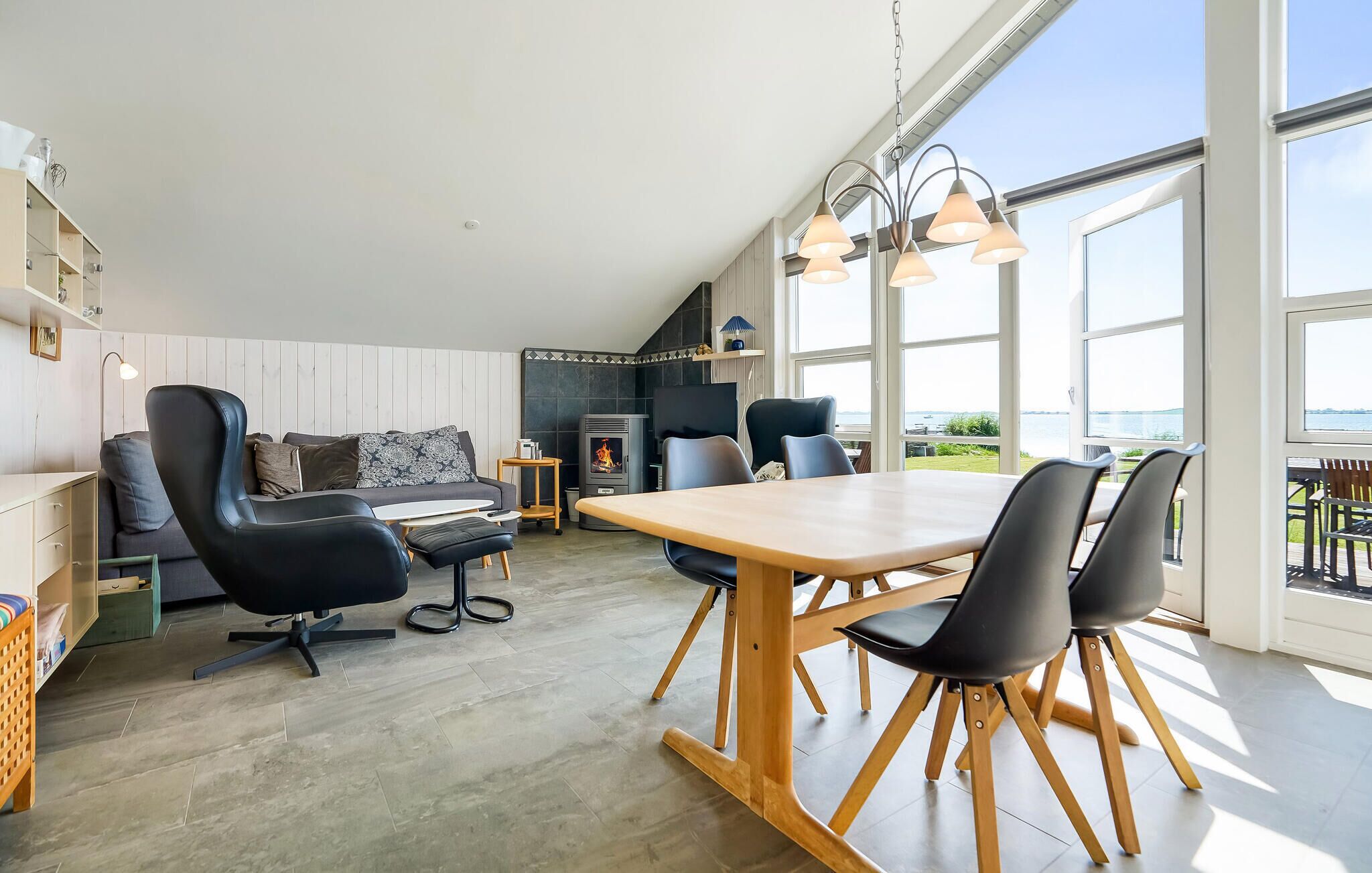 Un grand salon comprenant un canapé, des fauteuils, une table à manger et une cheminée.