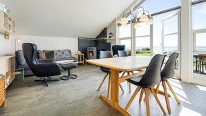 A spacious living area with a sofa, chairs, a dining table, and a fireplace. - Gorgeous home in Faaborg with sauna (Faaborg)
