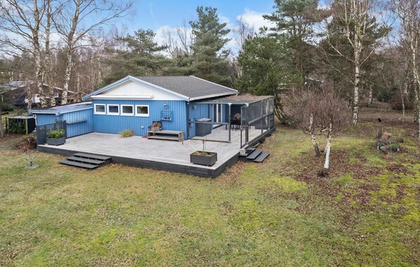 Relax on the covered patio or screened porch, surrounded by a wooded area.