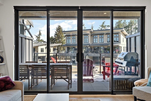 Un salon moderne doté d’une porte-fenêtre coulissante donnant sur un patio extérieur.