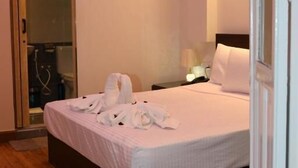 A bedroom with a bed, a nightstand, a lamp, and a shower area. - Mid Downtown Hotel (Cairo)
