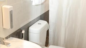 A bathroom with a white sink, toilet, and a shower curtain. - Mid Downtown Hotel (Cairo)