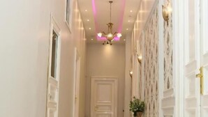 A hallway with a marble floor, white walls, and a ceiling with recessed lighting. - Mid Downtown Hotel (Cairo)
