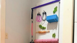 A small workout area with a pegboard wall, shelves with weights, and a pink exercise ball. - Cozy King Bedroom w/Bath in Historic Savannah (Savannah)