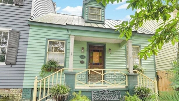 A two-story house with a green exterior, a front porch with a bench, and a small garden area. - Cozy King Bedroom w/Bath in Historic Savannah (Savannah)