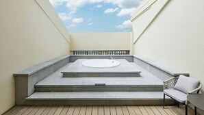 A rooftop terrace with a stone pool, steps, and a wicker chair. - Four Points By Sheraton Anshun, Huangguoshu (Anshun)