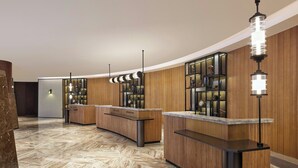 A reception area with wooden paneling, marble flooring, and modern pendant lighting. - Four Points By Sheraton Anshun, Huangguoshu (Anshun)