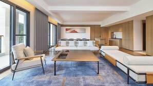 A modern living room with a sofa, a chair, a coffee table, and a TV. - Four Points By Sheraton Anshun, Huangguoshu (Anshun)