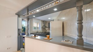 Eine moderne Küche mit grauer Arbeitsplatte, einem eingebauten Herd und einem großen Fenster.