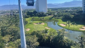 Un sistema di funivia, un campo da golf e un grande edificio sullo sfondo.