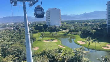A cable car system, a golf course, and a large building in the background.