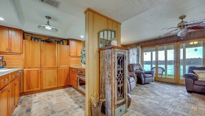 A spacious living area with a fireplace, a large window overlooking a body of water, and a cozy seating area with a leather sofa and armchairs. - River-View Condo w/ Boat Slip in Welaka! (Welaka)