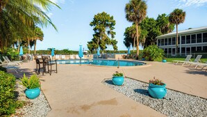 A pool area with lounge chairs, a table, and potted plants. - River-View Condo w/ Boat Slip in Welaka! (Welaka)