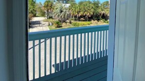 A view from a balcony with a white door, a blue railing, and a clear blue sky. - Charming 2bedroom condo on the canal a dock available. In beautiful Gulf Shores! (Gulf Shores)