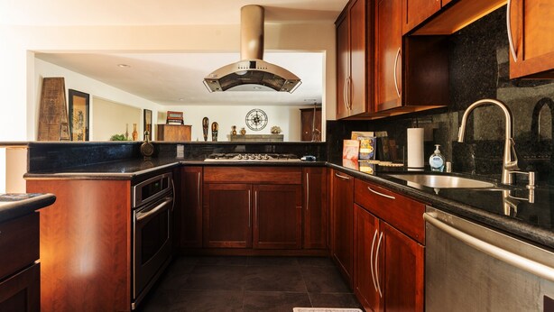 Una cocina con armarios de madera, un lavamanos de acero inoxidable y un horno empotrado.