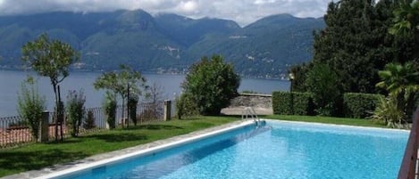Piscina com vista para montanhas e um lago.