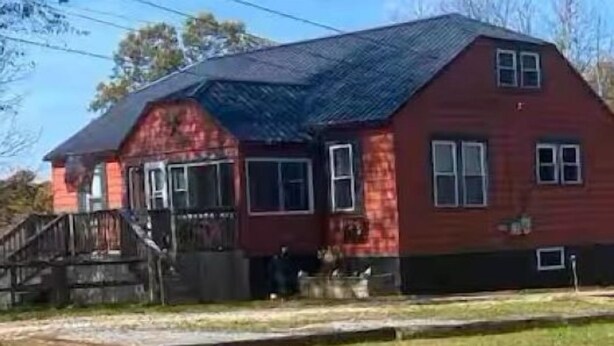 A two-story red house with a black roof, a front porch, and a visible address number. - The Sasquatch Hideaway: Private 1BR Adventure Loft (Fayetteville)