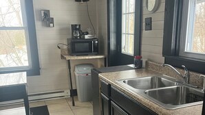 A compact kitchen with a sink, a microwave, and a coffee maker on the countertop. - The Sasquatch Hideaway: Private 1BR Adventure Loft (Fayetteville)