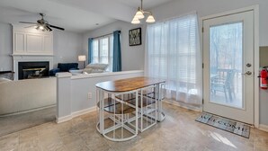 Una cocina moderna con una isla central, armarios blancos y un ventilador de techo.