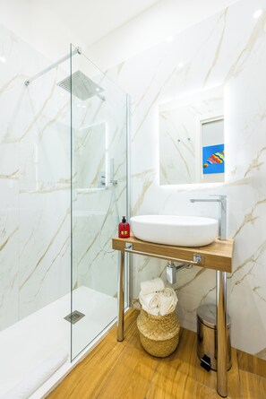 Habitación triple Deluxe, balcón, vista a la ciudad | Baño | Batas, toallas, jabón, shampoo 