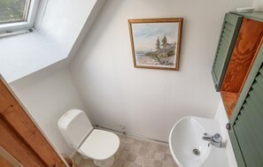 A bathroom with a toilet, sink, and a framed painting on the wall. - Gorgeous home in örkelljunga with WiFi (Örkelljunga)