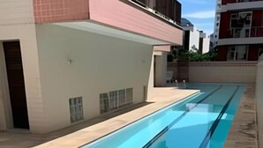 A long, narrow swimming pool adjacent to a building with a tiled exterior. - Sua Casa no Rio Ipanema 2Qts com Garagem (Rio de Janeiro)