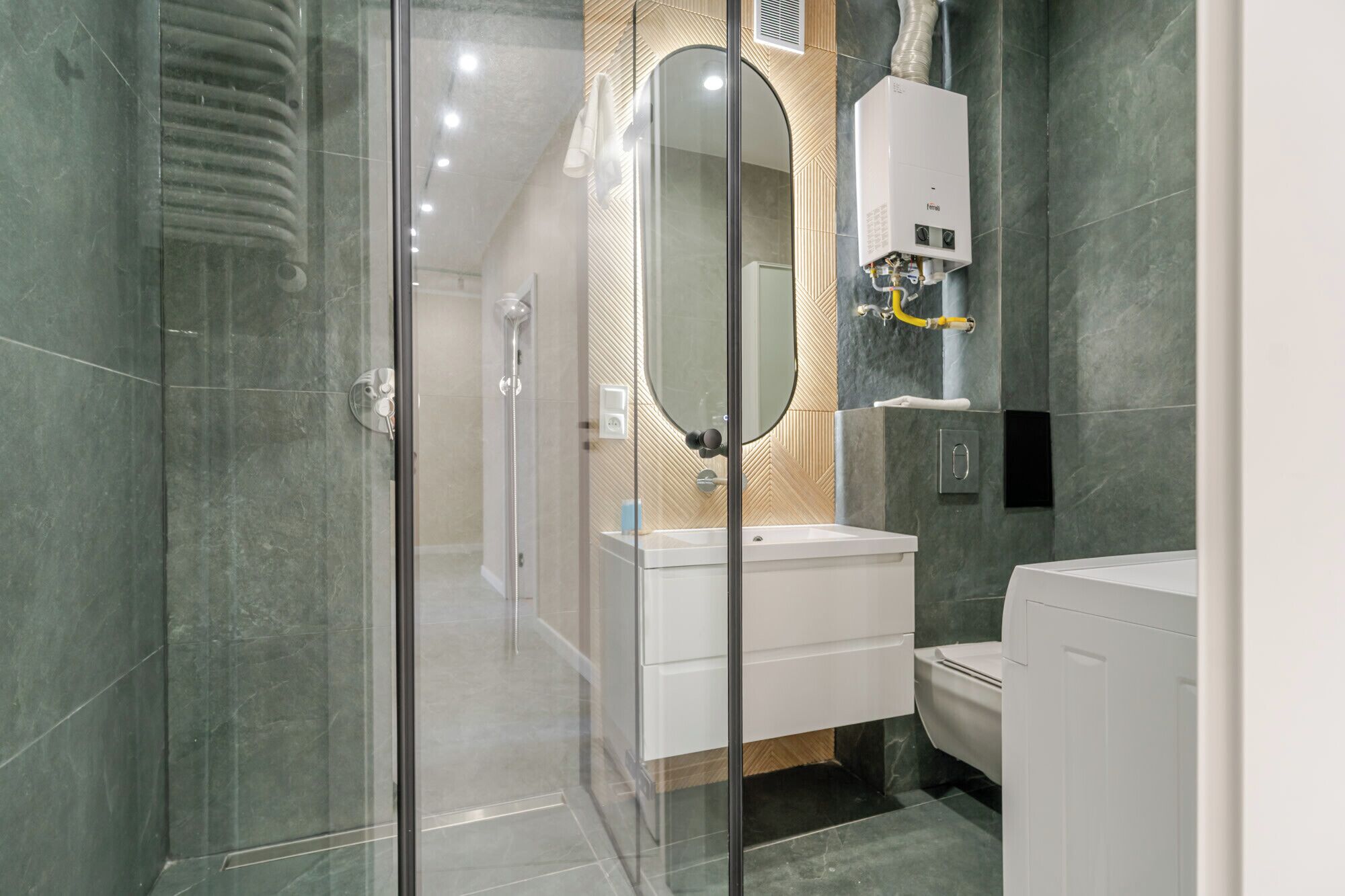Une salle de bain moderne avec une douche à parois de verre, un lavabo blanc et des toilettes.