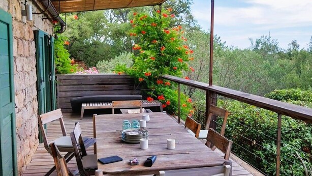Un área de comedor al aire libre con una mesa de madera, sillas y un banco.
