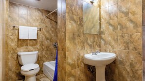 A bathroom with a toilet, sink, and bathtub.