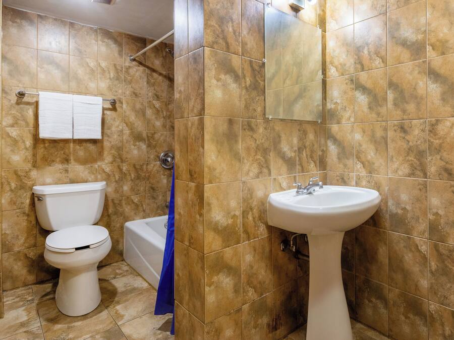 Een badkamer met toilet, wastafel en bad.