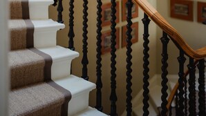 Un escalier en colimaçon avec une rampe en bois et des balustres noires.